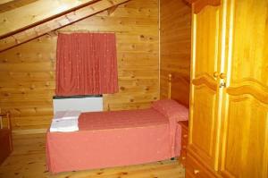 Habitación pequeña con 1 cama en una cabaña en CASA DE MADERA ZUMACAR VI en Cazorla