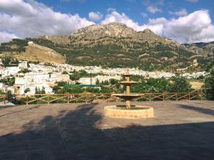 a fountain in front of a city with a mountain at CASA DE MADERA ZUMACAR VI in Cazorla