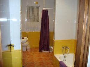 a yellow bathroom with a toilet and a tub at El Hogar de Ardwina in Alía