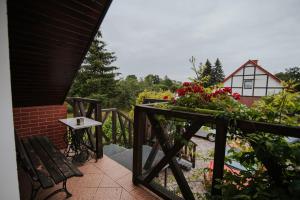 un balcón con un banco y flores y una casa en Agroturystyka Małgosia en Lubiąż