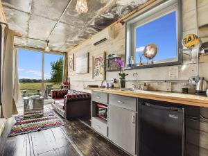 een keuken met een wastafel en een bank in een kamer bij FlopHouze Shipping Container Hotel in Round Top