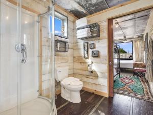 a bathroom with a toilet and a shower at FlopHouze Shipping Container Hotel in Round Top