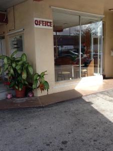 a store front with a patio area with chairs and tables at Palacio Inn Motel in Miami