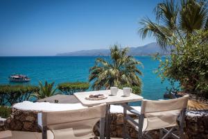 a table and chairs with a view of the ocean at Skajado Holiday Apartments in Stalís
