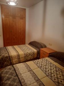 um quarto com 3 camas e um armário de madeira em PLAZA MAYOR em El Ejido
