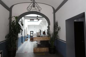 an office with an archway and plants in a hallway at Hotel Sofia in Puebla