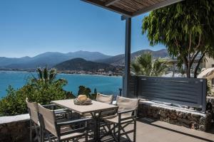 a table and chairs on a patio with a view of the water at Skajado Holiday Apartments in Stalís