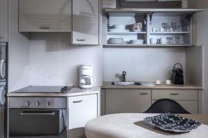 a kitchen with white cabinets and a table and a counter at Skajado Holiday Apartments in Stalís