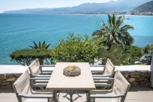 a table and chairs with a view of the ocean at Skajado Holiday Apartments in Stalís