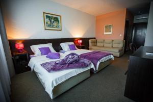 a bedroom with a large bed with purple sheets at Hotel Sv. Mihovil in Trilj