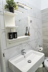 Melanthi Apartment في كيراموتي: حمام أبيض مع حوض ومرحاض