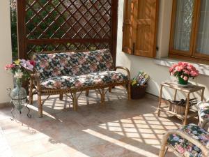 a patio with two chairs and a table with flowers at La Quercia e il Gelso in Baricella