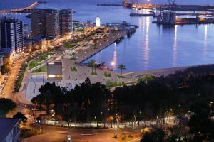 a view of a city with a harbor at night at LA BELLA MALAGUETA in Málaga