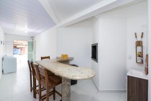 cocina con mesa y sillas en una habitación en Residencial Melfi III - Apartamento Térreo, en Bombinhas
