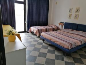ポルト・エンペードクレにあるAl Caos Da Pirandello - Alloggio Vacanza Ufficioのベッド2台と窓が備わるホテルルームです。
