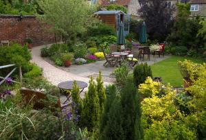 um jardim com mesas, cadeiras e flores em 17 Burgate em Pickering