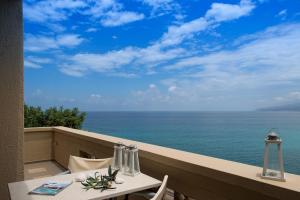 a table and chairs on a balcony overlooking the ocean at Skajado Holiday Apartments in Stalís