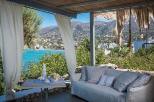 a couch on a patio with a view of the ocean at Skajado Holiday Apartments in Stalís