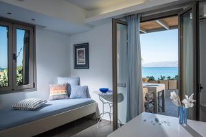 a bedroom with a bed and a view of the ocean at Skajado Holiday Apartments in Stalís