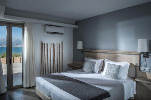 a hotel room with a bed and a large window at Skajado Holiday Apartments in Stalís