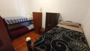 Hostelmo Hotel في بوينس آيرس: غرفة نوم صغيرة مع سرير وسرير بطابقين