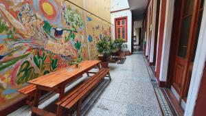 a corridor with a painting on the wall and benches at Hostelmo Hotel in Buenos Aires