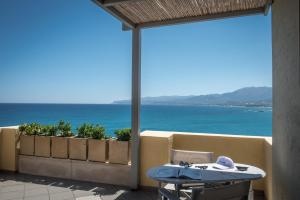 a patio with a table and a view of the ocean at Skajado Holiday Apartments in Stalís