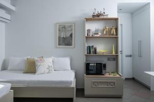 a bedroom with a bed and a tv on a shelf at Skajado Holiday Apartments in Stalís