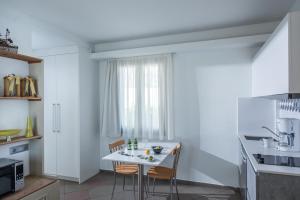 a kitchen with a white table and chairs at Skajado Holiday Apartments in Stalís