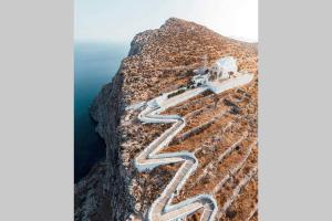 a road on the side of a mountain at Family house by the seaside of Karavostasis in Karavostasi