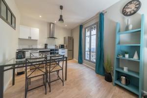 亞維儂的住宿－Elegant 2br with 2 bathrooms and AC close to Les Halles dAvignon Welkeys，厨房配有餐桌和墙上的时钟