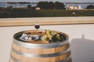 a plate of food and a glass of wine in a barrel at Stella Fenicia in Marsala