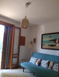 a living room with a blue couch and a pendant light at Casa Poesia in Torre dell'Orso
