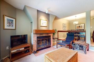 a living room with a fireplace and a television at The Gables 39 in Whistler