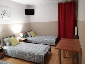 a hotel room with two beds and a couch at Pokoje Gościnne z Prywatną Łazienką dla firm in Gliwice