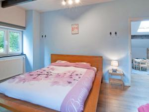 een slaapkamer met een bed met een roze dekbed bij Holiday Home in Xhoffraix between Spa and Eifel Nature Park in Xhoffraix