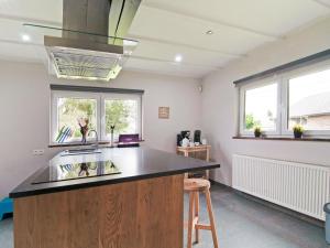 a kitchen with a counter and a sink and two windows at Holiday Home between Spa and Eifel Nature Park in Xhoffraix