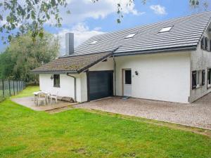 een wit huis met een garage en een grasveld bij Holiday Home in Xhoffraix between Spa and Eifel Nature Park in Xhoffraix