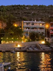 a building next to a body of water at night at Vila Bilo in Primošten