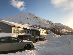 two cars parked in front of a house covered in snow at MelisHome: Aurora Observatory in Tromsø