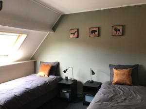 um quarto com 2 camas e uma janela em Beekhoeve em Scherpenzeel