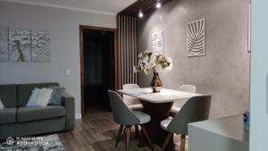 a living room with a table and chairs and a couch at Lindo apartamento no centro de Canela in Canela