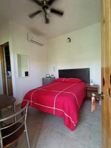 a bedroom with a large bed with a red blanket at Casa Bahía Suite 1 in Zihuatanejo