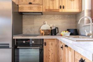 a kitchen with wooden cabinets and a stove top oven at Osada LUX-HOUSE & SAUNA in Zakopane