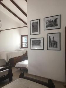 1 dormitorio con 1 cama y cuadros en la pared en Villa Anedé en Río Ceballos