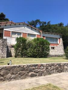 a house with a stone wall in front of it at Villa Anedé in Río Ceballos