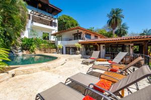 um pátio com cadeiras e uma piscina em Luxury Ocean-View Flamingo Home with Pool, Apartment and Party Deck em Playa Flamingo