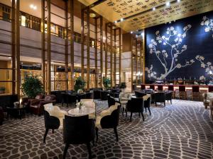 a restaurant with tables and chairs in a building at Pullman Zhangjiajie Hotel - Instagrammable in Zhangjiajie