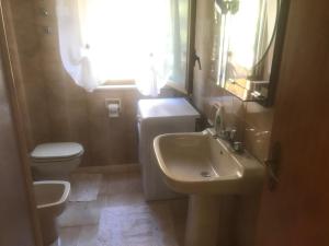 Un baño con lavabo, inodoro y ventana. en due passi dal mare, en San Vito lo Capo 17 fotos más