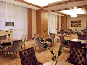 - un restaurant avec des tables et des chaises dans une salle dans l'établissement Mercure Istanbul Altunizade, à Istanbul